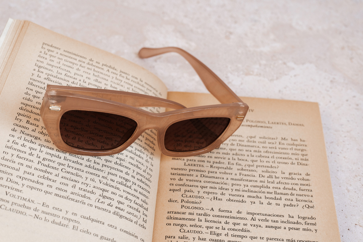 Brown Sunglasses with Book on Marble Background
